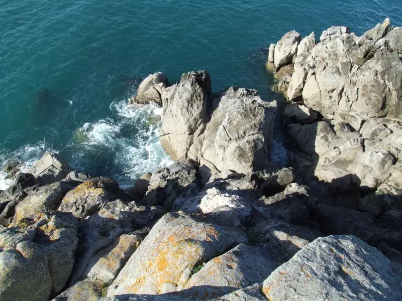 Looking down at the granite rocks and churning water at the blowhole on Moturiki Island, Mt Maunganui