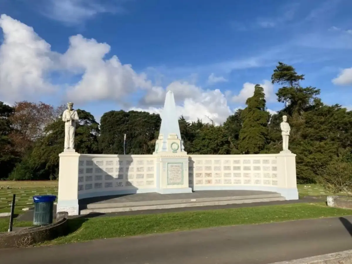 Large white World War One memorial with central obelisk and two soldier statues at Waikaraka Cemetery Onehunga