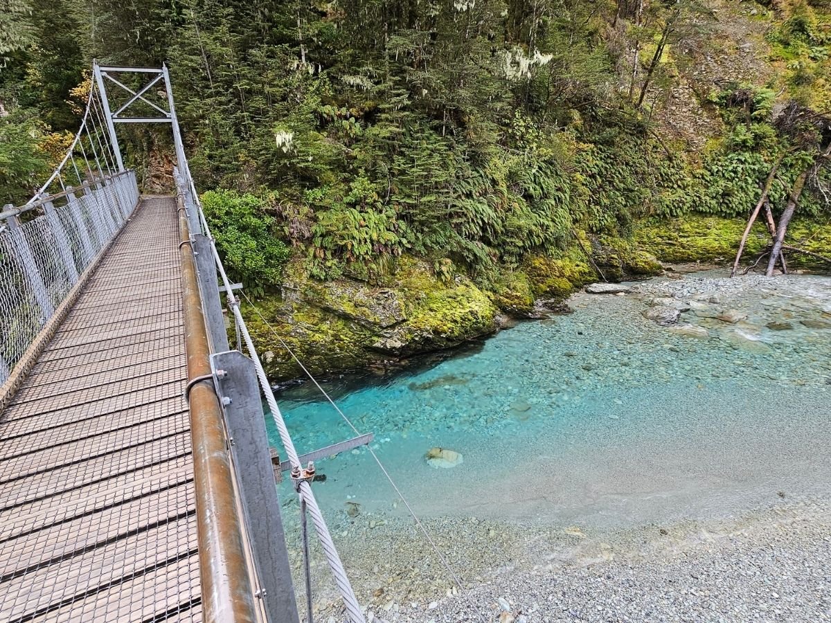Looking down from the swing bridge over the clear turquoise Route Burn at the start of the Routeburn Track